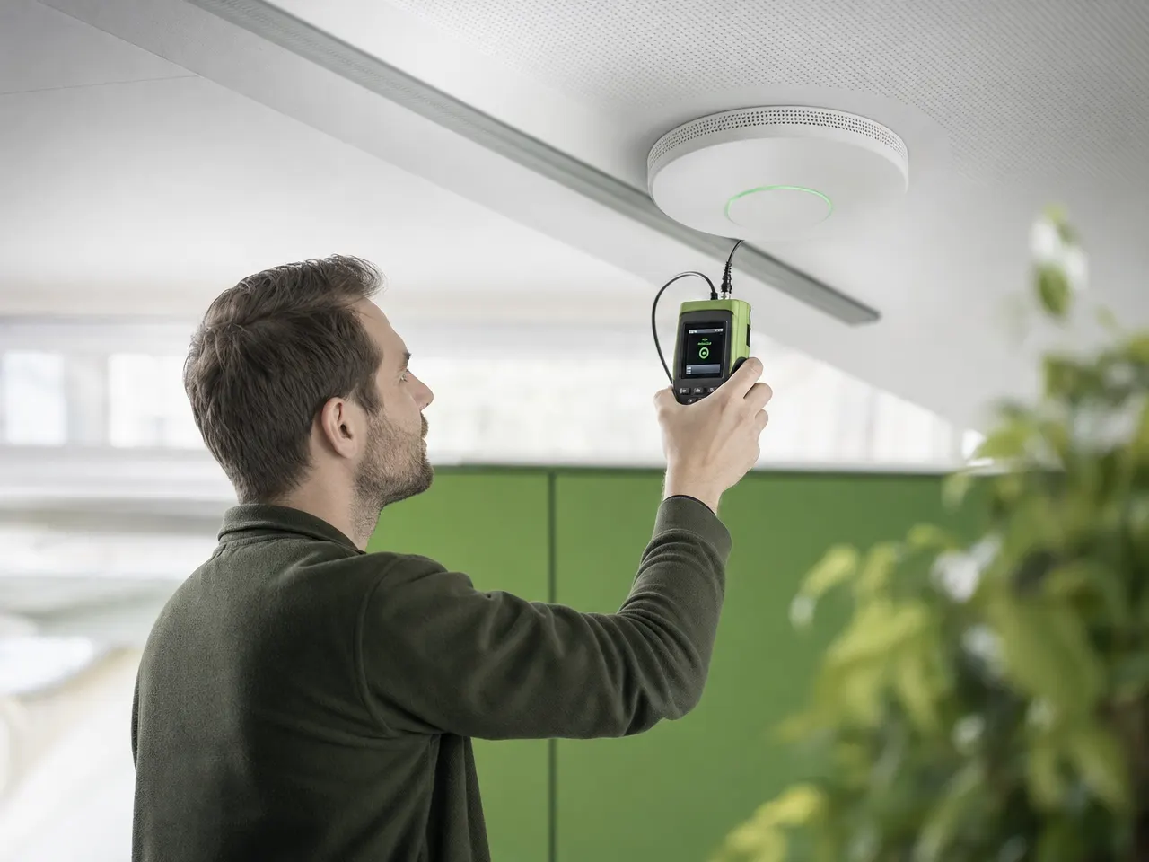 Techniker prüft die Funkabdeckung an einem Access Point mit einem Messgerät