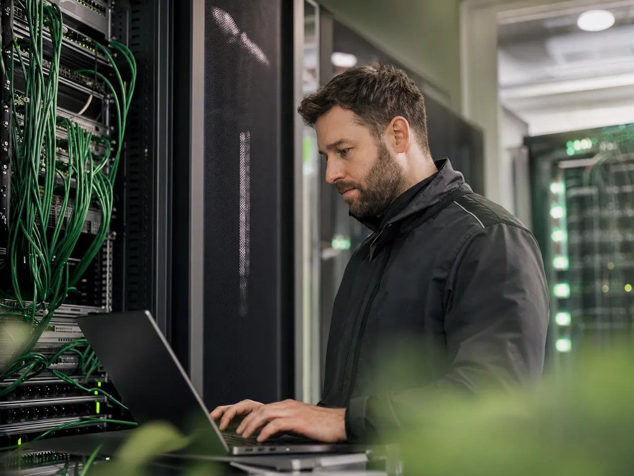 Techniker begleitet eine Umstellung im Serverraum an einem Notebook