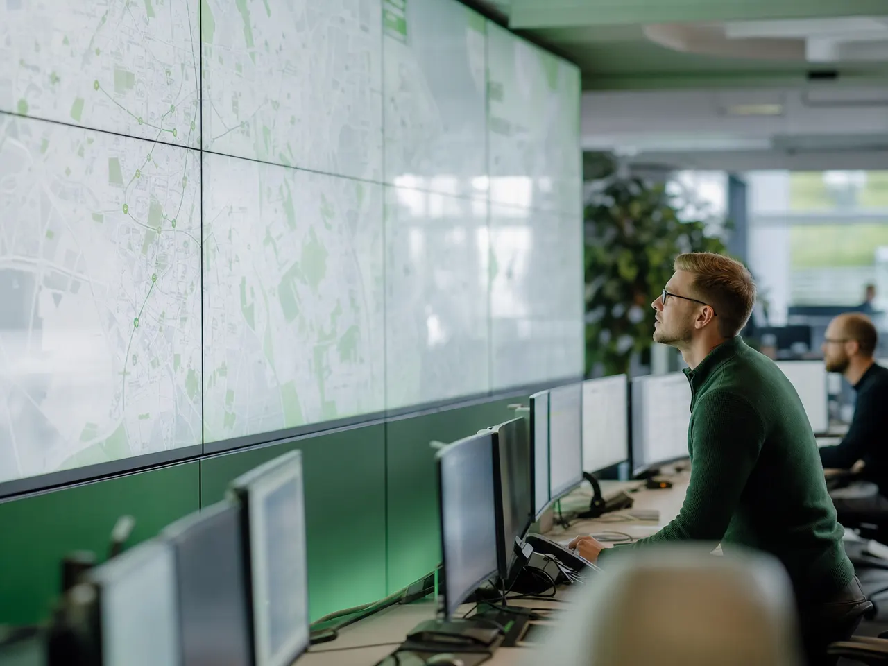 Monitorwand in einer Leitwarte mit Netzwerktechnik im Vordergrund